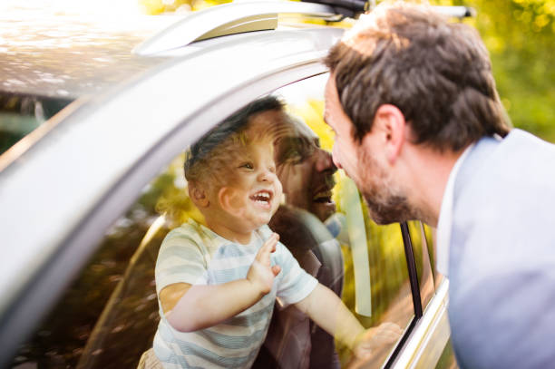 istock Little boy in the car looking at his father. 865049176