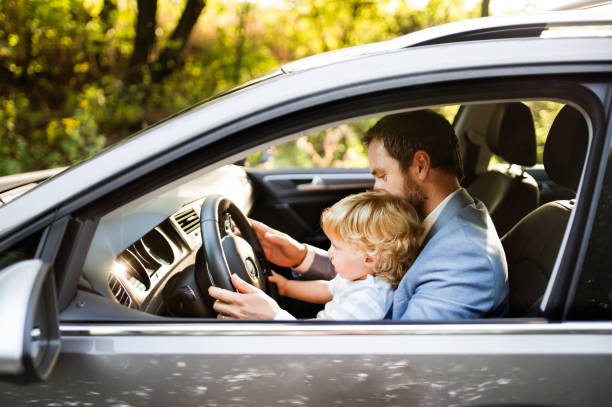 istock Man driving a car with little son. 865049196