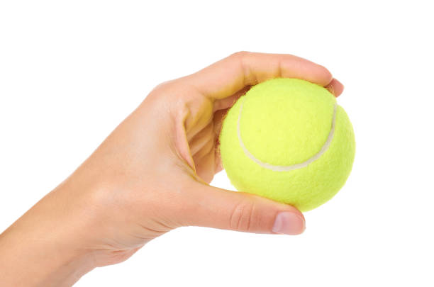 istock Single tennis ball in hand isolated on white background 865067078