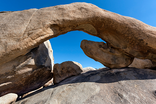 A natural arch among the granite boulders of Joshua Tree National Park in southern California.