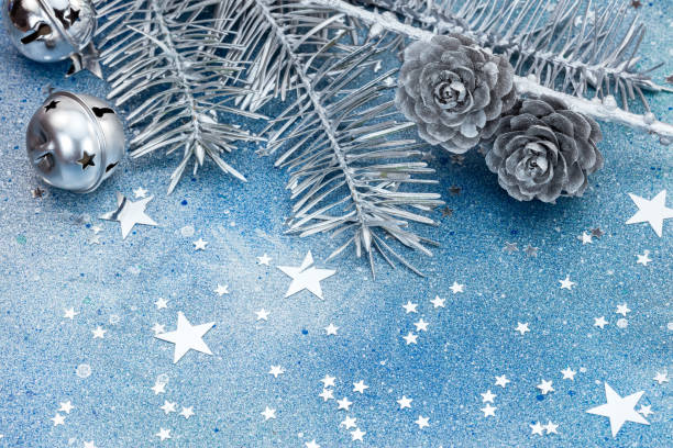 istock silver christmas tree branches with cones, decorations and sparkling stars on blue background 865070318