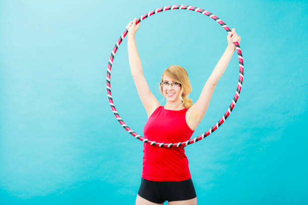 istock Fit woman with hula hoop doing exercise 865074176