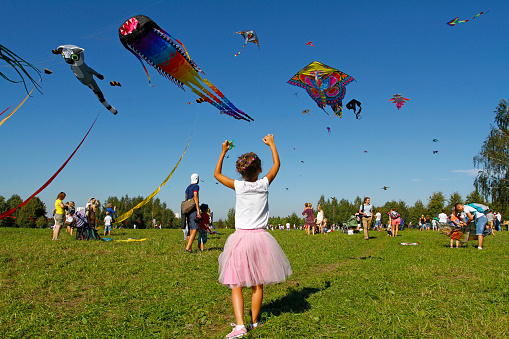 Moscow, Russia - August 27, 2016: Girl launches a kite into the sky at the kite festival in the Park Tsaritsyno in Moscow
