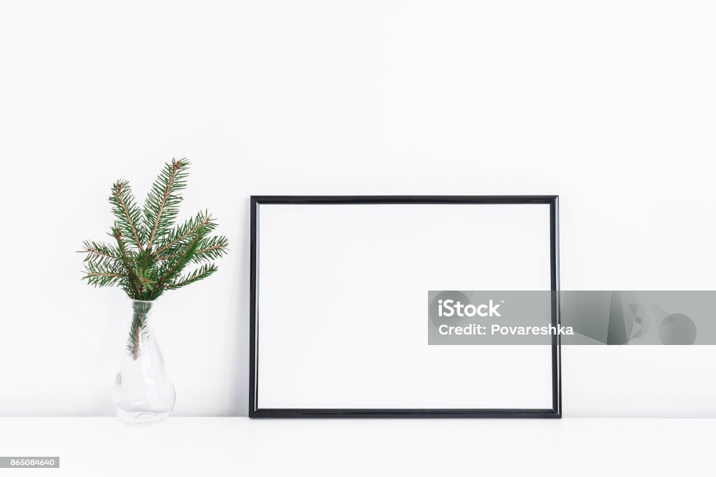 Black frame and christmas tree branches. Front view Christmas composition. Black frame and christmas tre branches on white background. Front view, mock up, copy space Picture Frame Stock Photo