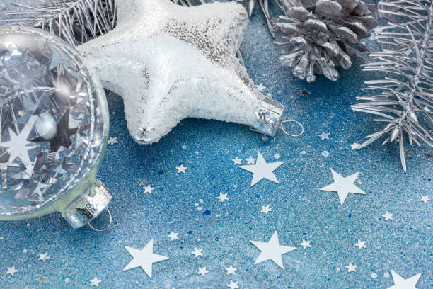 istock christmas tree decorations on blue glitter background with star sparkling confetti 865085072