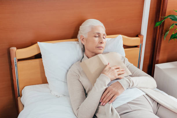 istock senior woman with book in hospital 865102780