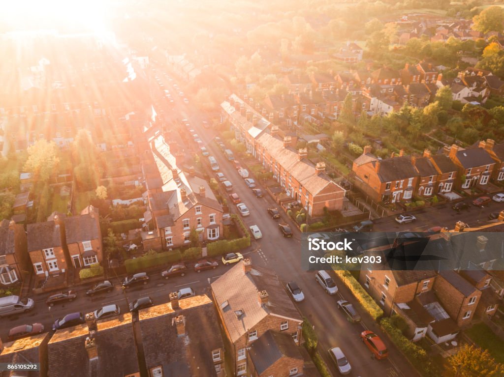 Aerial view of the sun setting over a cross roads in a traditional UK suburb Sun setting over a traditional British neighbourhood. Lens flare and warm colours to give a homely effect. UK Stock Photo
