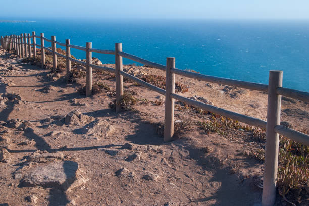 istock View od Cabo da Roca in Sintra - Roca Cape - cliffs and fence at sunset 865114884