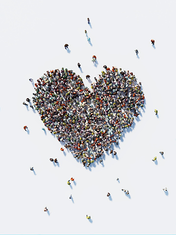 Human crowd forming a big heart shape on white background. Vertical composition with copy space. Clipping path is included. Love and donation concept.