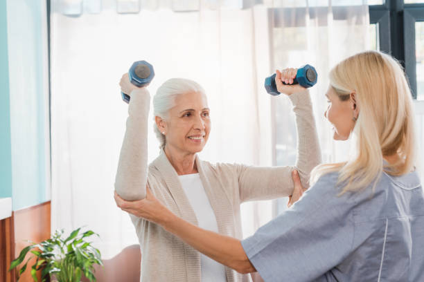 istock nurse and senior woman with dumbbells 865135270