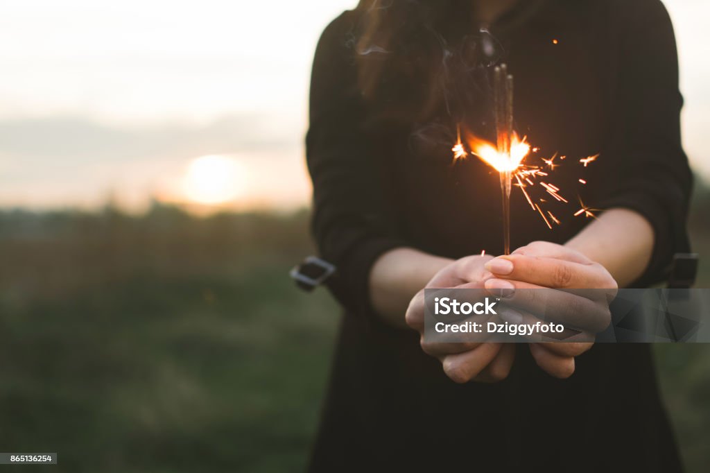 Celebration time Young woman celebrating New Year and holding sparkler Adult Stock Photo