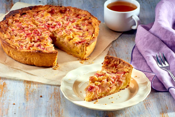 Homemade pie with rhubarb and custard on wooden table stock photo