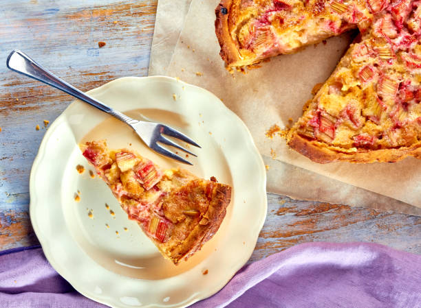 Homemade pie with rhubarb and custard on wooden table. Top view
