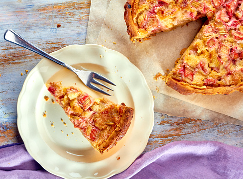 Homemade pie with rhubarb and custard on wooden table. Top view