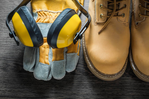 istock Protective gloves working lace boots ear muffs on wooden board 865140284