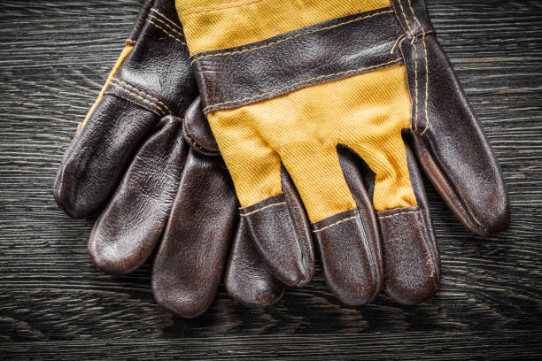istock Safety gloves on wooden board top view 865140364