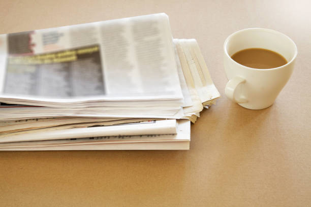 istock Newspaper with coffee on brown background 865149532
