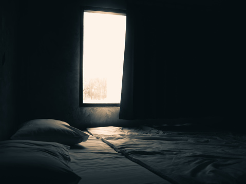 Dark bedroom with light from the window.