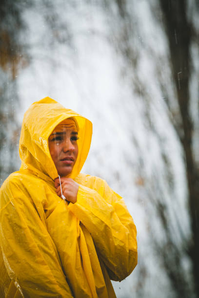 istock Scared woman standing on the rain in yellow jacket 865163008
