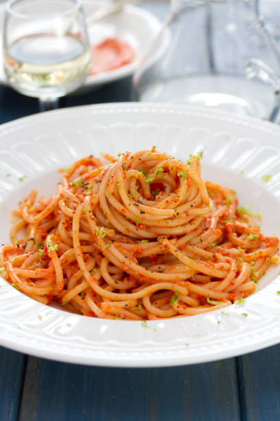istock spaghetti with sauce on white plate on blue wooden background 865163334