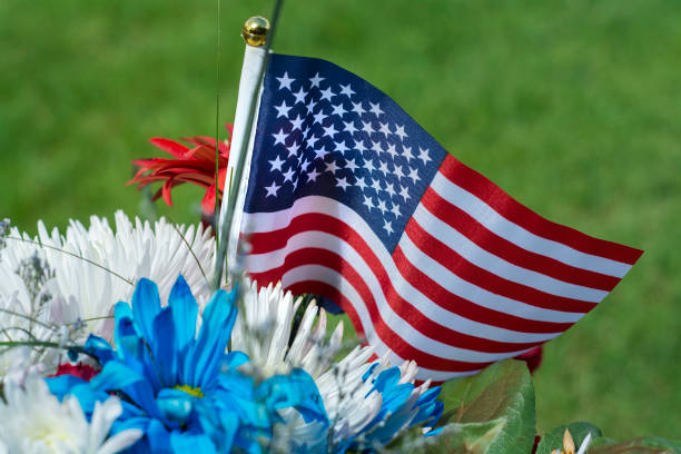 bandiera americana e fiori per il memorial day - camposanto monumentale foto e immagini stock