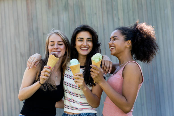 istock Three beautiful girls standing outdoors eating ice cream 865223774