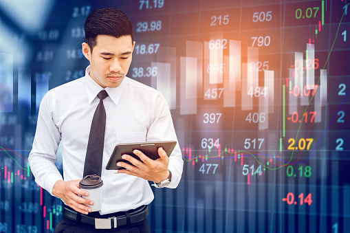 Businessman Using Digital Tablet on digital stock market financial exchange information and Trading graph background