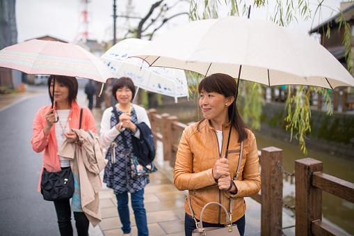 Japanese female friends walking along river