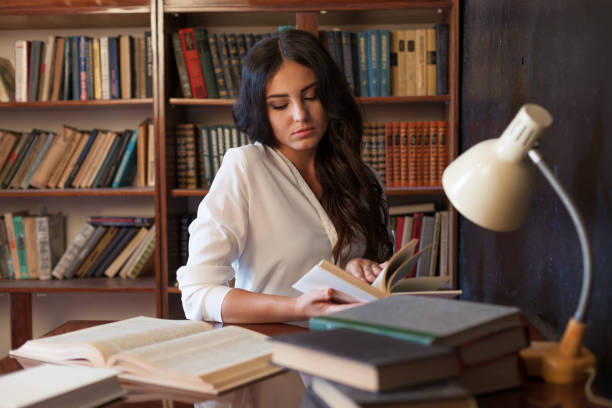 istock girl sitting at the table reading a book is preparing for the exam 865246326