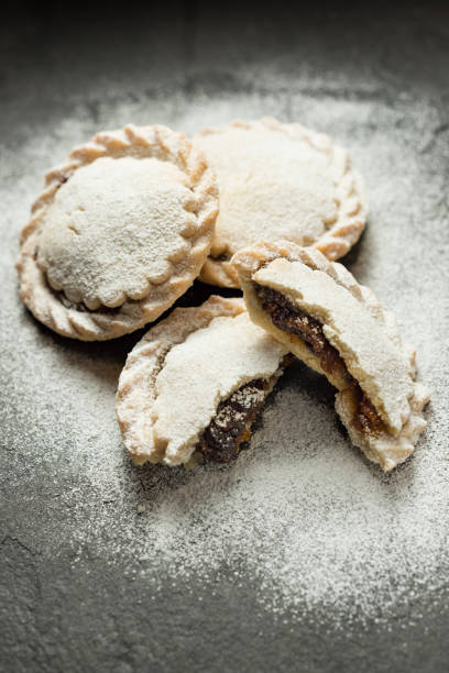 istock Mince pies dusted in icing sugar, split with filling exposed. 865248848