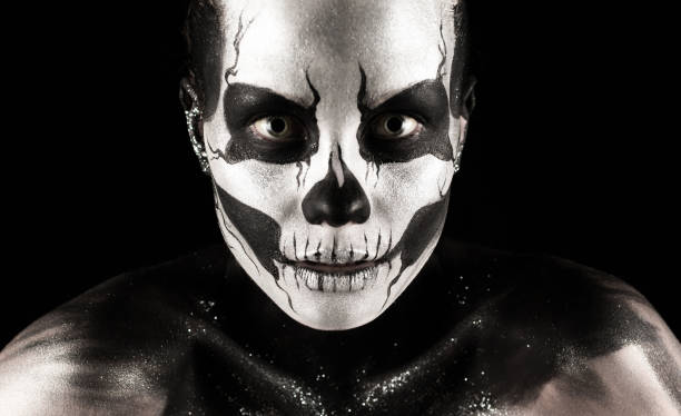 Isolated on black, closeup picture, beautiful young blonde caucasian woman with scull body art, grey eyes, serious look