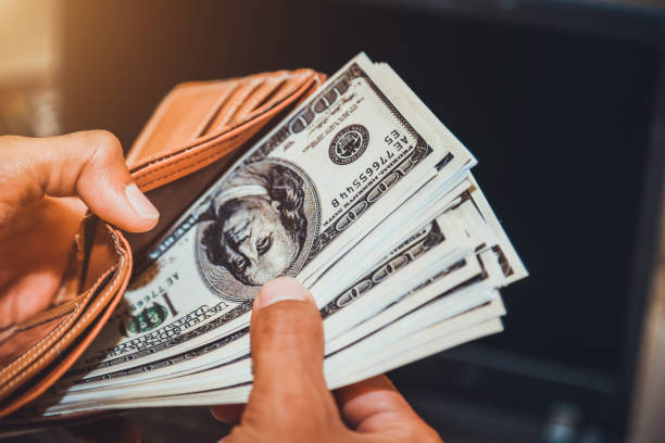 istock Hands holding us dollar bills and money pouch. 865260536