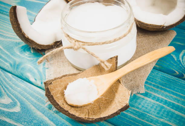 istock Coconut oil and fresh coconuts on a wooden table. 865279270