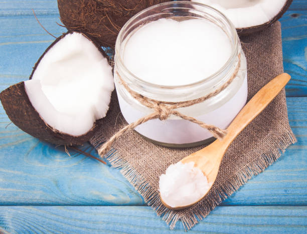 istock Coconut oil and fresh coconuts on a wooden table. 865279890