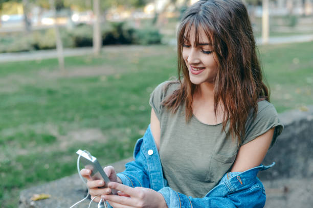 istock Young female  student talking on the phone   in the park 865283608