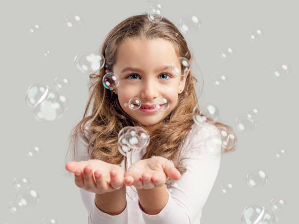 istock Girl playing with soap bubbles 865288368