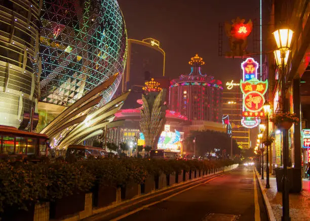 Streets of Macau at night lit up by casino neon lights