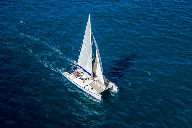 Catamaran navigating Aerial view of a catamaran navigating in the Indian Ocean catamaran sailing boats stock pictures, royalty-free photos & images