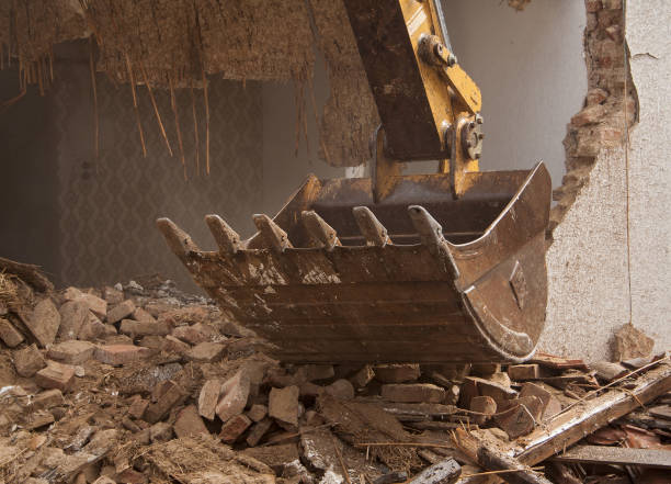 A large track hoe excavator tearing down an house A large track hoe excavator tearing down an old house garden hoe photos stock pictures, royalty-free photos & images
