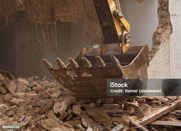 A Large Track Hoe Excavator Tearing Down An House Stock Photo - Download Image Now - Demolishing, House, Demolished
