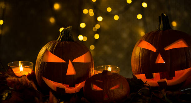 istock Halloween pumpkin head jack lantern with burning candles 865309476