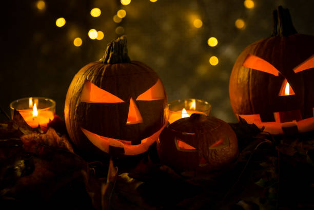 istock Halloween pumpkin head jack lantern with burning candles 865309502