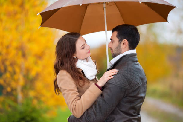 istock Couple of lovers under umbrella in the rain. 865310930