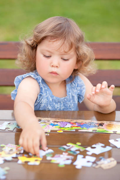 istock Adorable happy little child playing with puzzle. 865314232