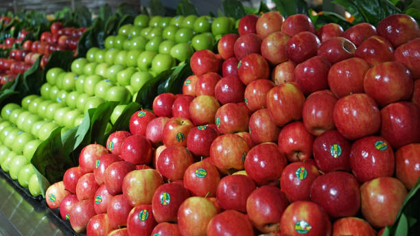 fruit aisle with piles of red and green apples in supermarket - department store imagens e fotografias de stock