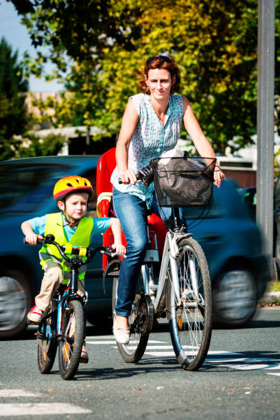 istock Mother and son crossing street riding bikes. 865320840