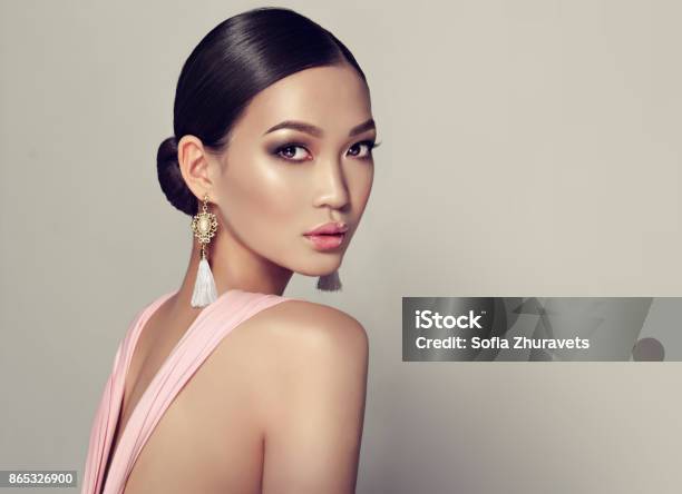 Young Gorgeous Asian Woman In A Smoky Eyes Style Make Up Dressed In A Tassel Earrings Stock Photo - Download Image Now