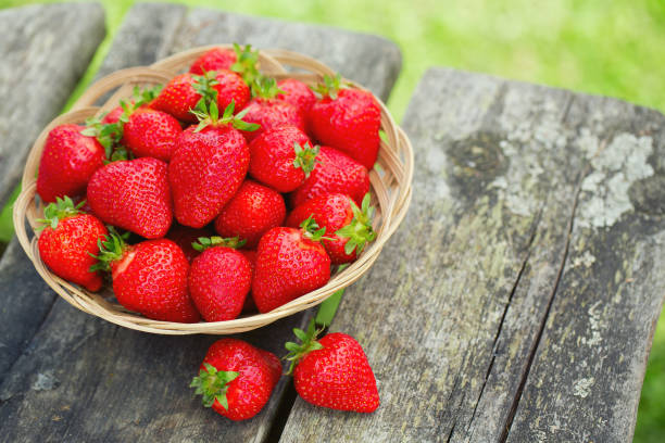 istock Basket with strawberries on a garden wooden table 865327672