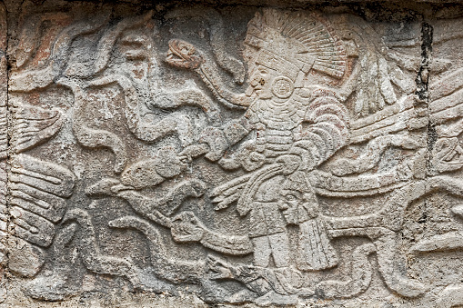 Small carved stone plaque in Uxmal showing  a Mayan King surrounded by snakes.