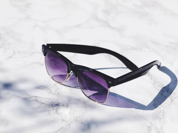 istock Stylish sunglasses isolated on white marble background in direct sunlight with shadows. Copy space. 865332034